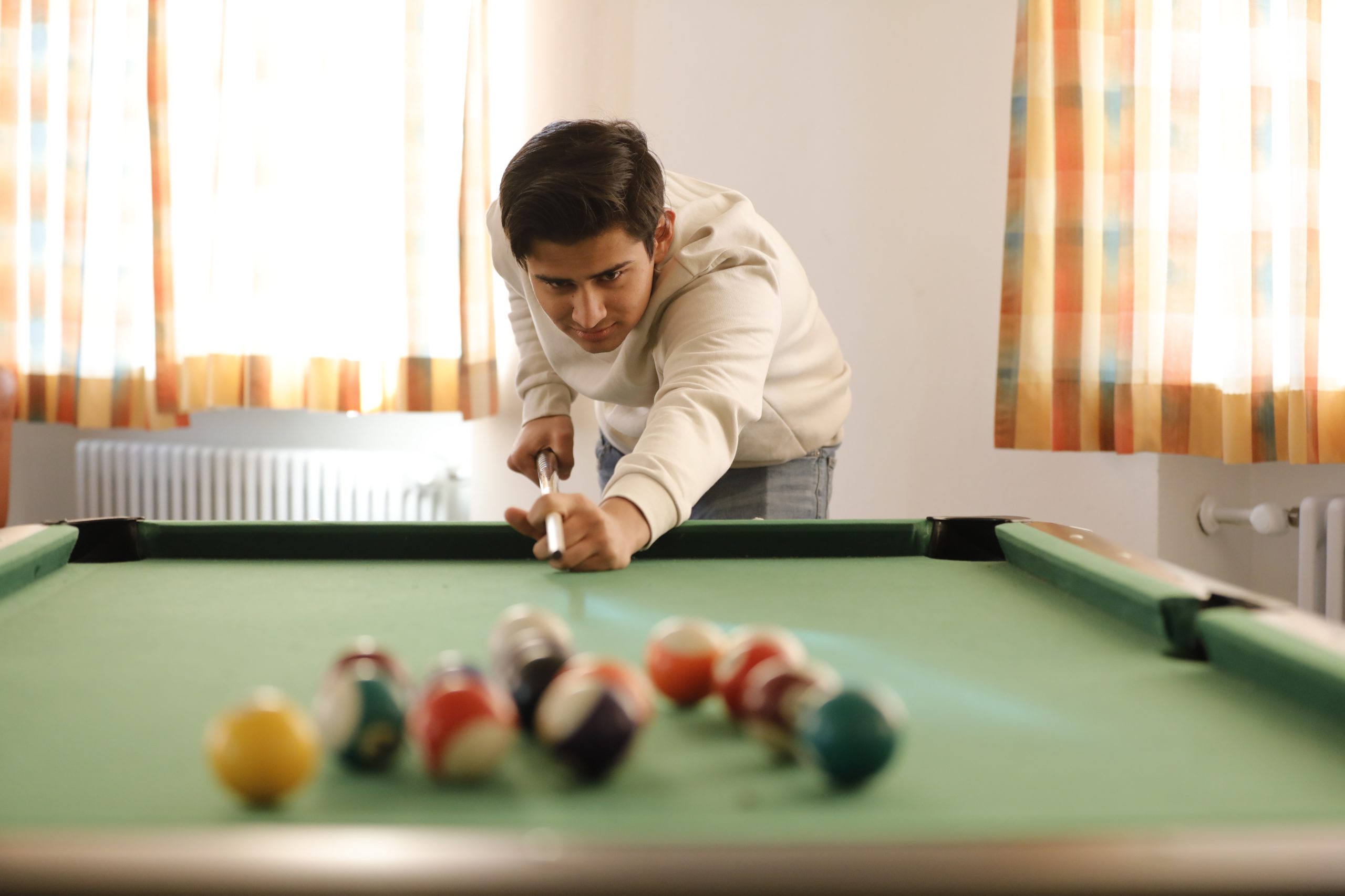 Jugendlicher spielt Billard