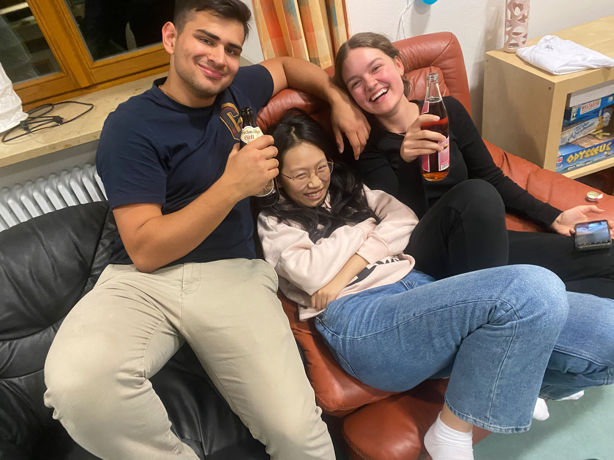 3 Jugendliche sitzen gemütlich auf bequemen Sesseln und lachen